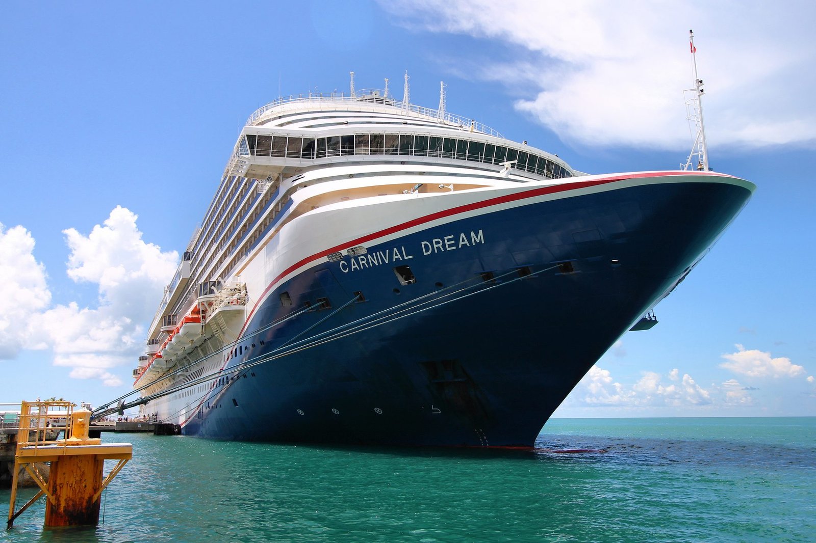 Carnival Dream docked in turquoise Caribbean water under a bright blue sky